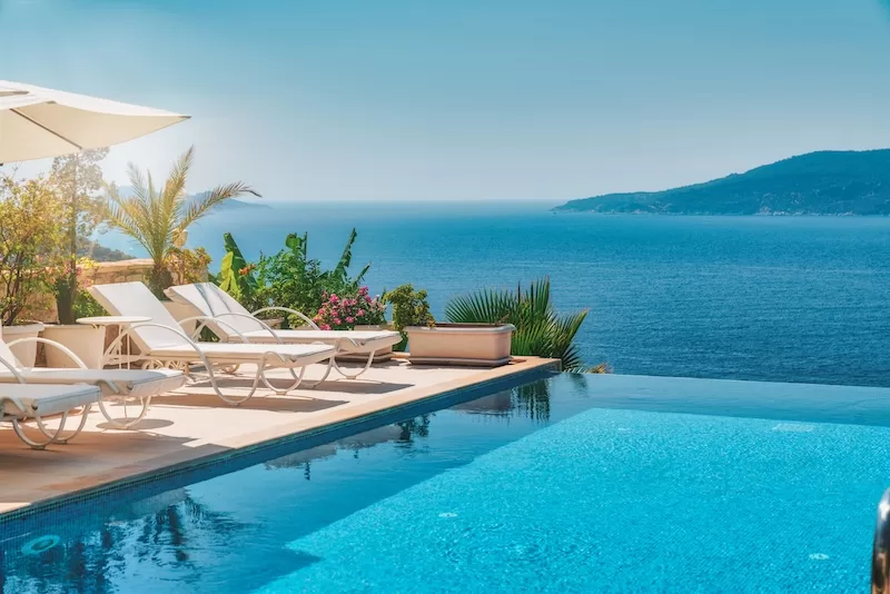 Sun loungers beside a villa infinity pool above the sea: the life the retirement savings gap seems to rule out, and living abroad can put back in reach