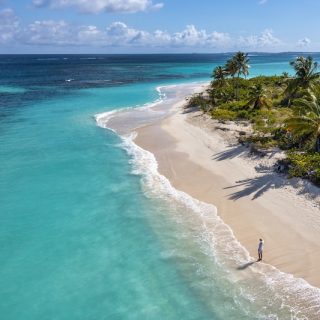 An empty Caribbean shoreline, the region where most citizenship by investment programs operate.