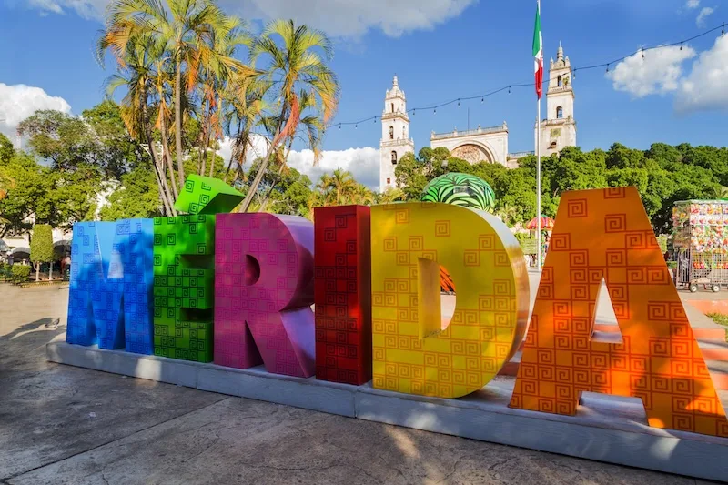 The colorful MÉRIDA letters on the Plaza Grande, the cathedral towers behind: the heart of living in Mérida