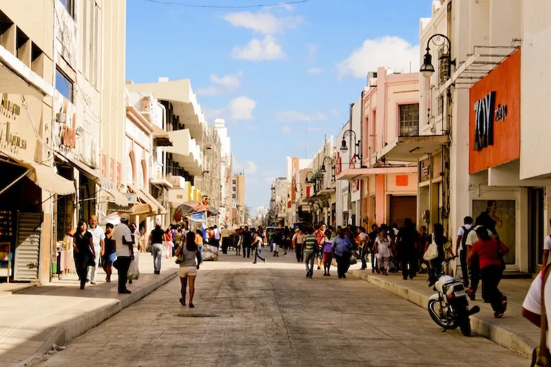 Shoppers walk a pastel-fronted street in Mérida’s historic center.
