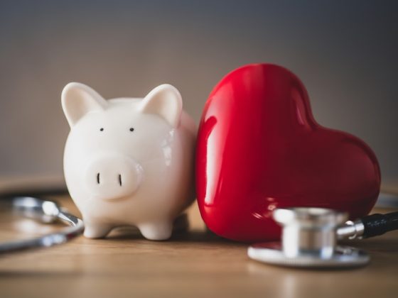 A piggy bank, a red heart and a stethoscope side by side: international asset protection covers wealth and health together.