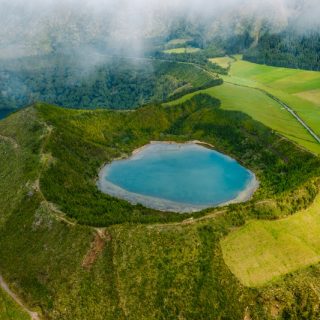 A blue crater lake among green hills on São Miguel in the Azores, one of the best islands for expats in Europe.