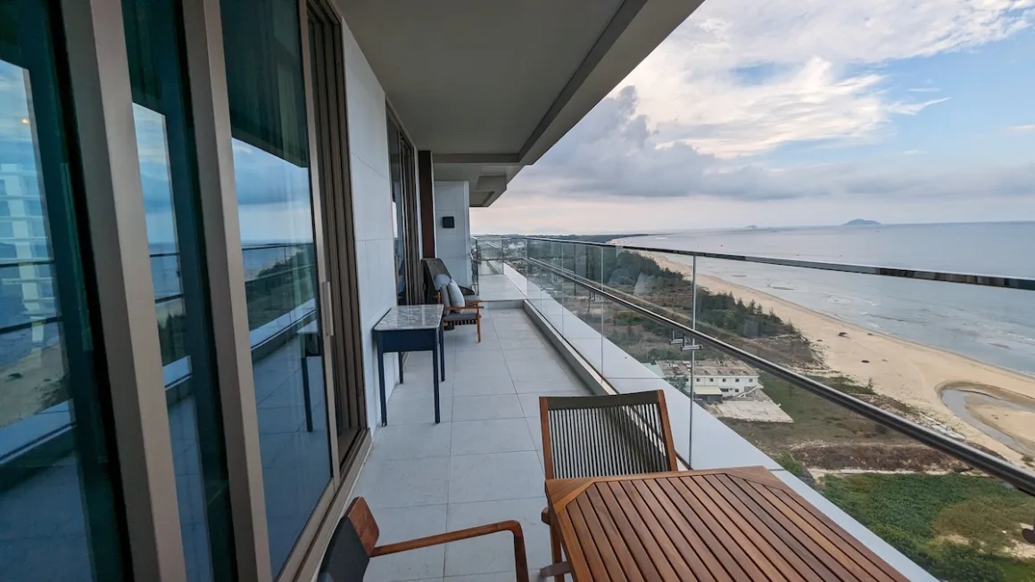 A long apartment balcony looking down a quiet sandy beach on Vietnam’s central coast.