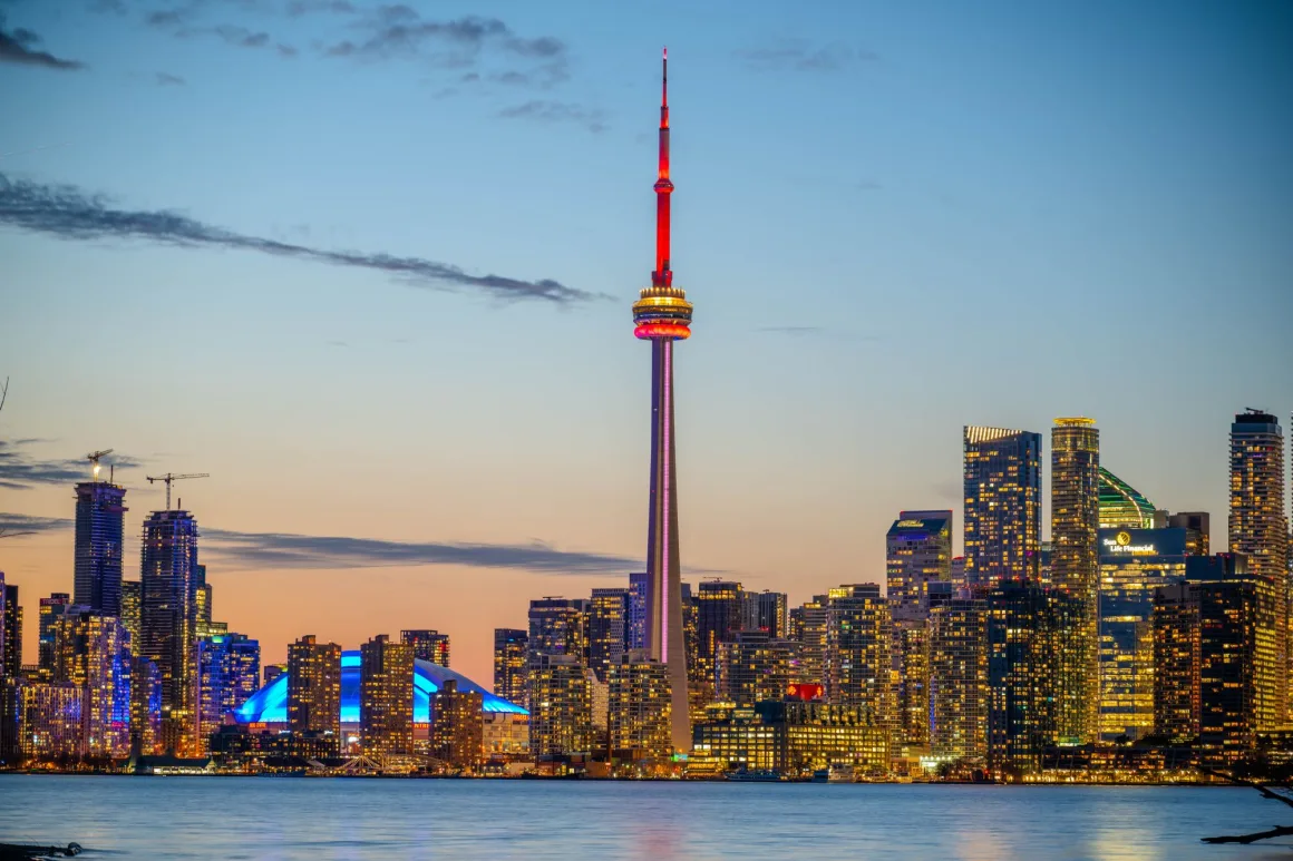 Toronto skyline and CN Tower at dusk across Lake Ontario