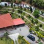 Aerial view of Casa Libélula, a red-roofed home with terraced gardens in the Malacatos Valley, the finished result of building a house in Ecuador.
