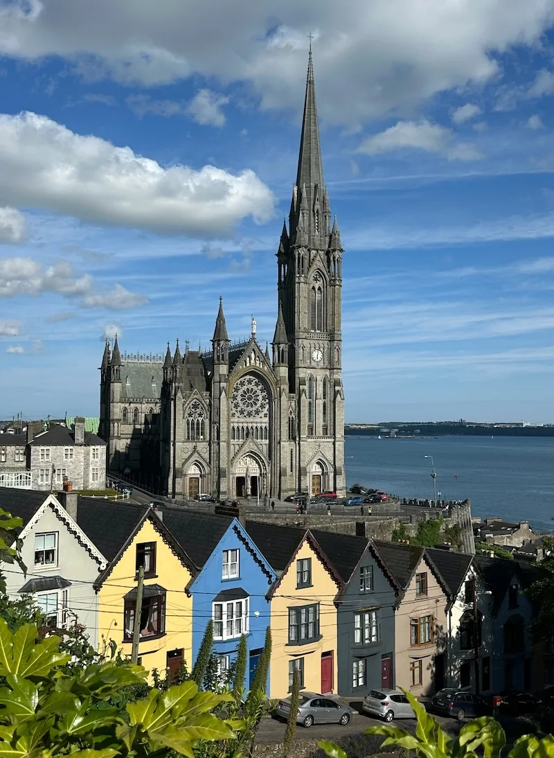 St Colman’s Cathedral rises above a row of colorful houses in Cobh, County Cork, Ireland.