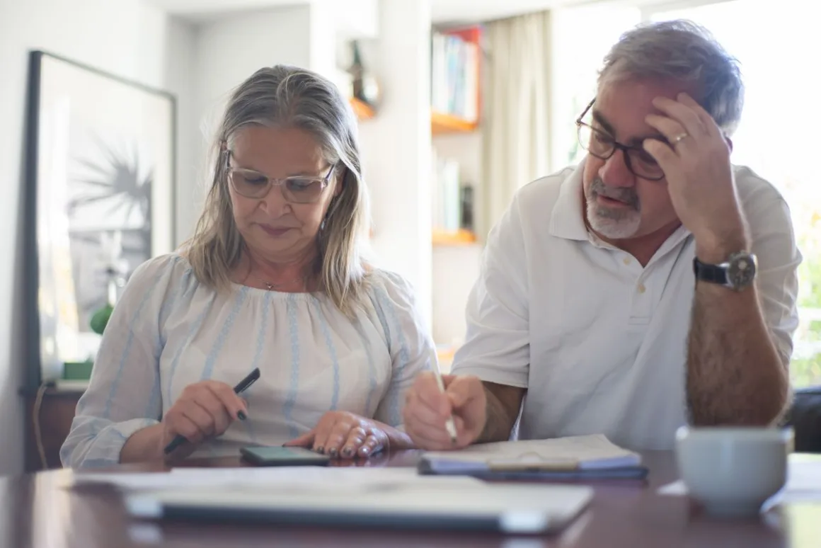 Senior couple working through household expenses at a desk