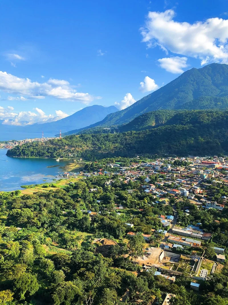 A lakeside village spreads beneath green volcanic slopes on the shore of Lake Atitlán.
