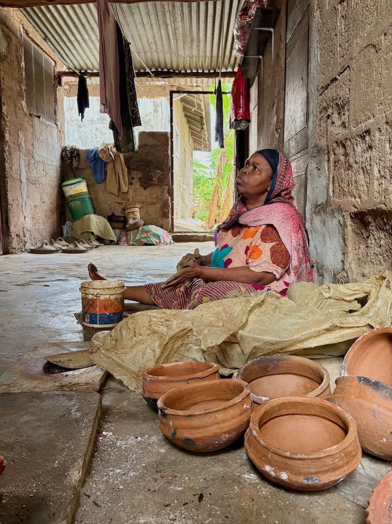 A craftswoman making clay pots in a Zanzibar workshop